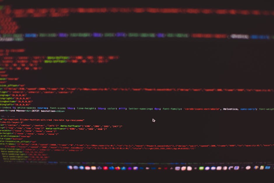 A close-up image of a computer screen displaying multicolored code in a dark-themed editor, with lines of HTML, CSS, and JavaScript visible in varying shades of red, green, blue, and purple. The code